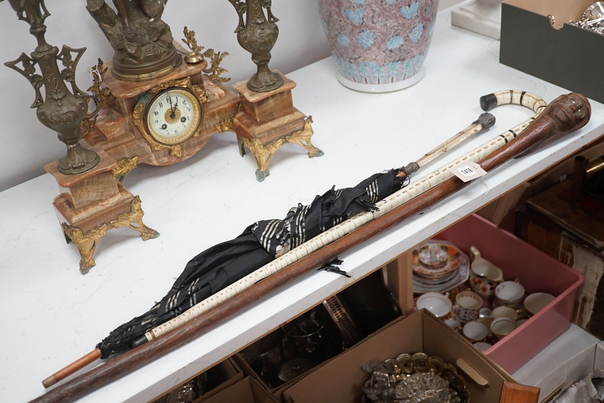 A carved wood figural walking cane, a vertebrae walking stick and a Victorian parasol. Longest 108cm